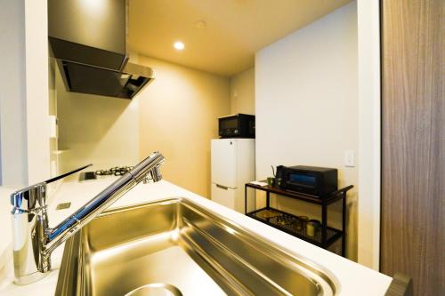 a kitchen with a sink and a refrigerator at Branchera Naha 1107 in Naha