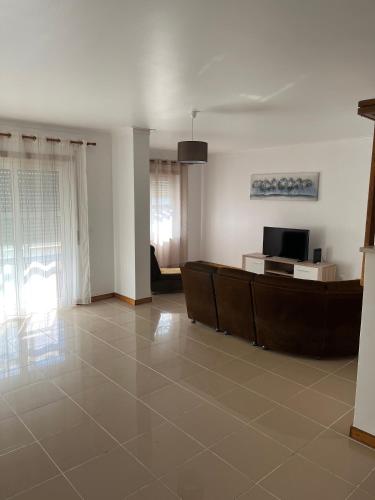 a living room with a couch and a television at Tome's House - Baleal Solvillage 2 in Ferrel