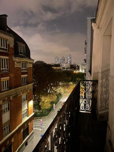 desde un balcón con vistas a una calle de la ciudad por la noche en Appartement a Paris en París