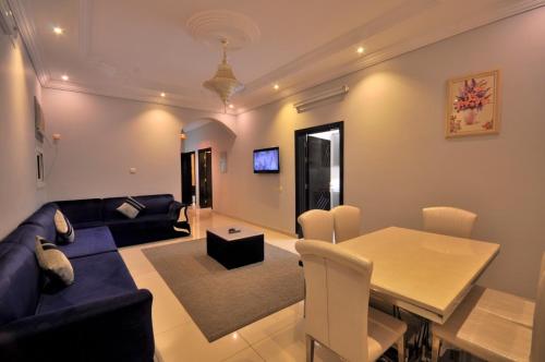 a living room with a blue couch and a table at Ritan Apart-Hotel in Taif