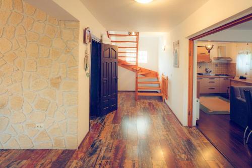 a hallway with a stone wall and stairs in a house at Casa de vacanta Isabelle in Comarnic