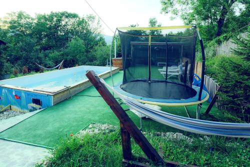Une balançoire est installée dans une cour avec un trampoline. dans l'établissement Casa de vacanta Isabelle, à Comarnic