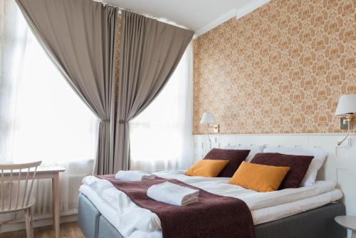a bedroom with a large bed with orange pillows at Boutique Hotel Lähde in Lappeenranta