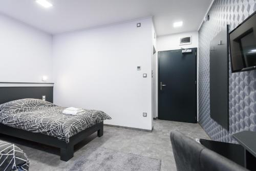 a bedroom with a bed and a flat screen tv at Theresa Vendégház in Kiskunmajsa
