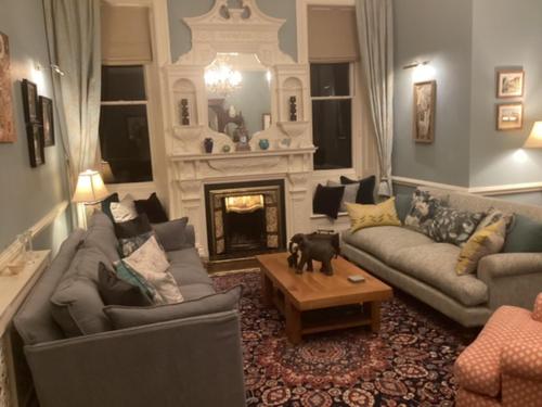 a living room with two couches and a fireplace at Brynffynnon Boutique Bed and Breakfast in Dolgellau