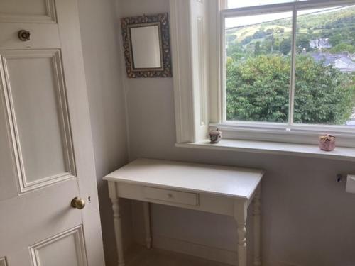 una mesa blanca en una habitación con ventana en Brynffynnon Boutique Bed and Breakfast, en Dolgellau