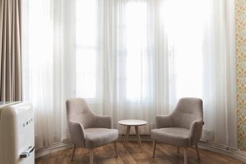 two chairs and a table in front of a window at Boutique Hotel Lähde in Lappeenranta