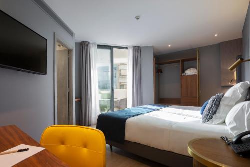 a hotel room with a bed and a desk and a television at Hotel Lima - Adults Recommended in Marbella