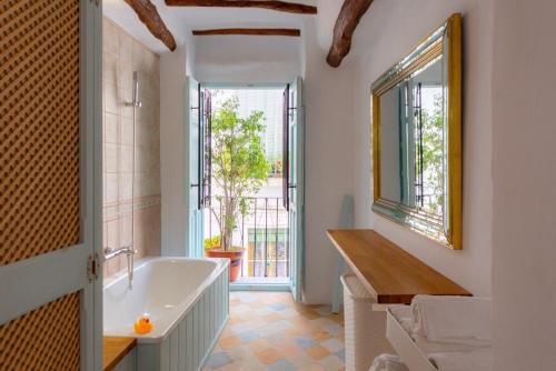 a bathroom with a tub and a large window at Casa Bonita Órgiva. in Órgiva