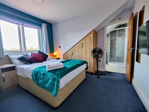 a bedroom with a large bed and a large window at Wellesley Hotel in Ilford
