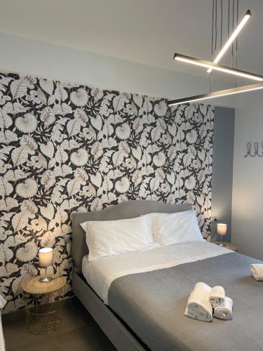 Un dormitorio con una cama con una pared de acento floral en Stella Rooms, en Catania