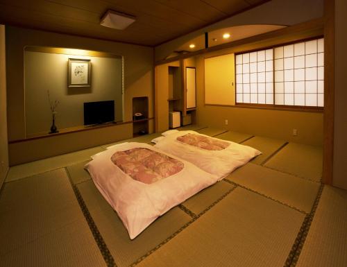 a bedroom with a large bed in a room at Kyoto Ryokan Hirashin in Kyoto