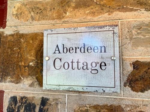a sign on a brick wall with the words aberged coffee at Aberdeen Cottage in Burra