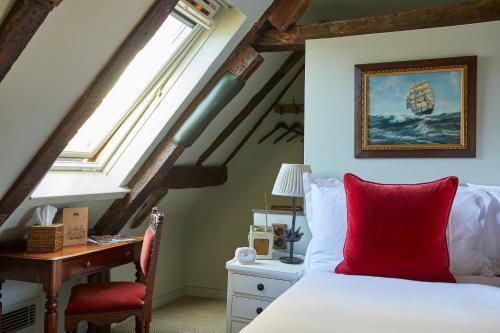 a bedroom with a bed with a red pillow and a desk at THE PIG in the Wall - Southampton in Southampton