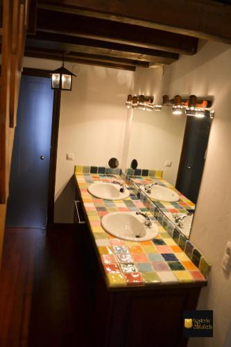 a bathroom with a counter with three sinks and a mirror at HdeC Hosteria de Castañeda Alojamiento Turistico in Puente Viesgo