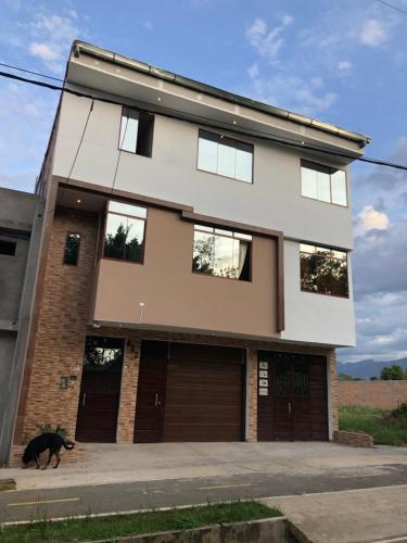 un cane nero che cammina davanti a una casa di CASA SHILCAYO Habitaciones Vacacionales a Tarapoto