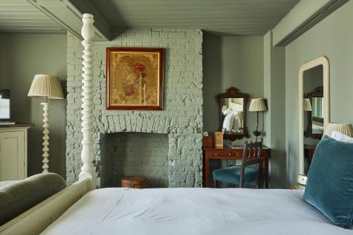 a bedroom with a bed and a fireplace at THE PIG in the Wall - Southampton in Southampton