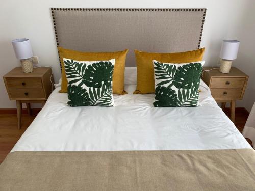 a white bed with two pillows and two night stands at Apartamentos Los Catorce, EL Hierro in Valverde