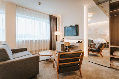 a living room with a couch and a desk with a television at Tallink Spa & Conference Hotel in Tallinn