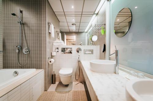 a bathroom with a tub and a toilet and a sink at Tallink Spa & Conference Hotel in Tallinn