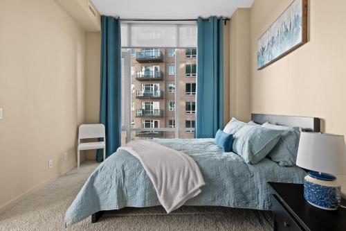 um quarto com uma cama com cortinas azuis e uma janela em Gorgeous Downtown Calgary Condos by GLOBALSTAY Free Parking em Calgary