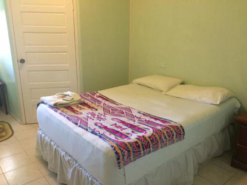 a bedroom with a bed with a blanket on it at Don Santiago Guesthouse Downtown in San Ignacio
