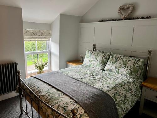 a bedroom with a bed and a window at Gorgeous 2-Bed Cottage in Penderyn Brecon Beacons in Aberdare