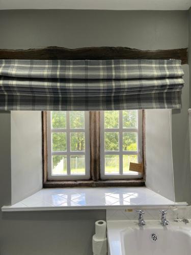 a window in a bathroom with a white sink and a sink at Marl Hill House in Clitheroe