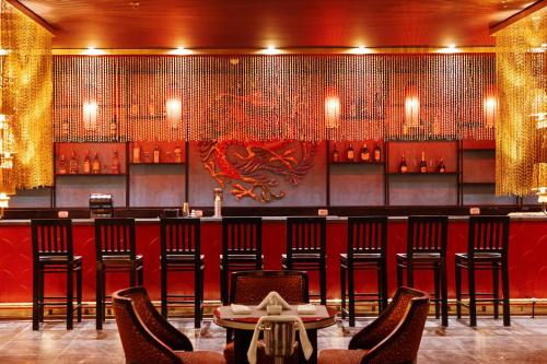 a restaurant with a bar with chairs and a dragon on the wall at Pickalbatros Blu Spa Resort - Adults Friendly 16 Years Plus- Ultra All-Inclusive in Hurghada