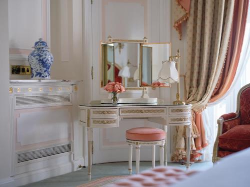 a dressing table with a mirror and a vase of flowers at The Ritz London in London