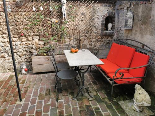 een tafel en stoelen op een bakstenen patio bij Appartement de charme in Honfleur