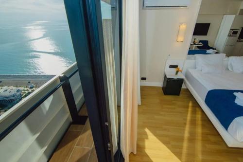 Superior Sea View Aparthotel in Orbi City Batumi في باتومي: غرفة نوم مع سرير وإطلالة على المحيط