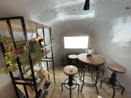 a room with a table and two stools and a shelf at TOCORO. Mt.Fuji The Airstream Kawaguchiko Station in Azagawa