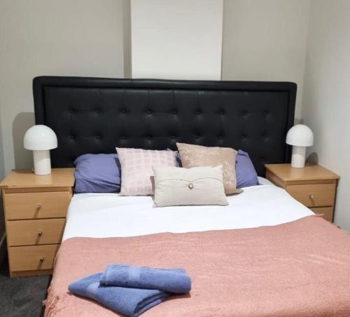 Un dormitorio con una cama grande con almohadas. en Collins central 2-bd apartment with pre-reserve parking, en Melbourne