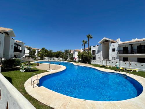a large swimming pool in the middle of a resort at Quiet & Spacious Apt @ Golf Course w/ Roof Terrace in San Roque