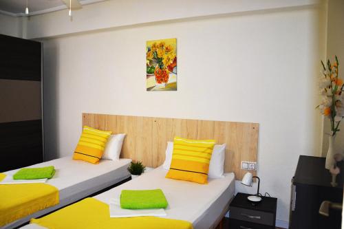 Duas camas num quarto com almofadas amarelas e amarelas em Double cozy room. Ruzafa - perfect place to stay em Valência