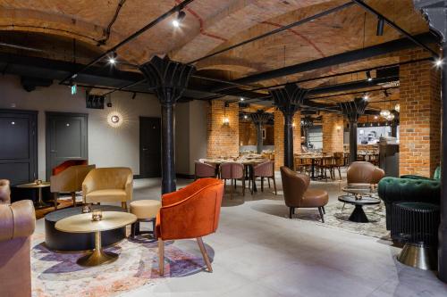 a restaurant with tables and chairs and brick walls at Browar Hevelius Apartments in Gdańsk