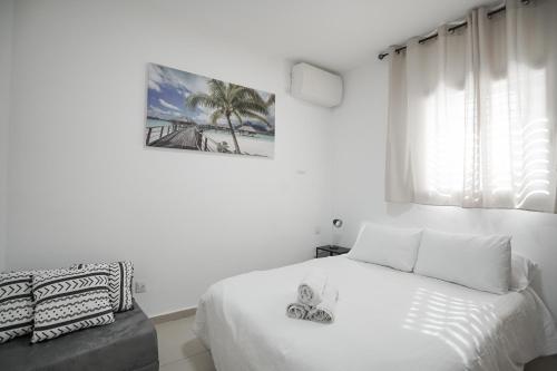 a white bedroom with a large bed and a window at Sea and Soul in Eilat