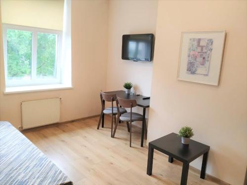 a small room with a table and a tv on the wall at Avitar in Rīga
