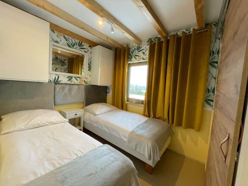 a small bedroom with two beds and a window at Apartament u Beti in Opole