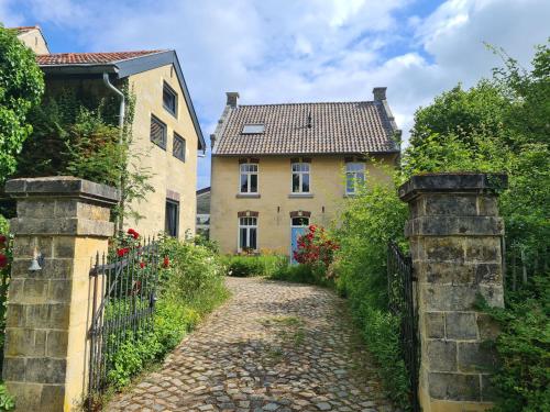 un camino de piedra que conduce a una casa con una puerta en Gastenverblijf 'De Mergelheuvel', Zuid-limburg, en Valkenburg