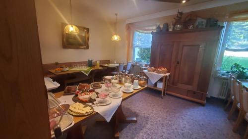 ein Esszimmer mit einem Tisch mit Essen drauf in der Unterkunft Landgasthof Steuber in Bromskirchen