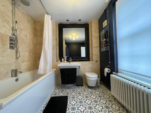 La salle de bains est pourvue d'une baignoire, de toilettes et d'un lavabo. dans l'établissement Gorgeous 2 bedroom apartment edge of Cabot Circus, à Bristol
