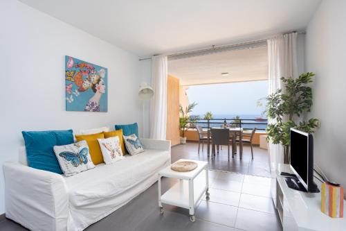 salon z białą kanapą i widokiem na ocean w obiekcie Frontline Penthouse with heated pool and parking w mieście Los Cristianos