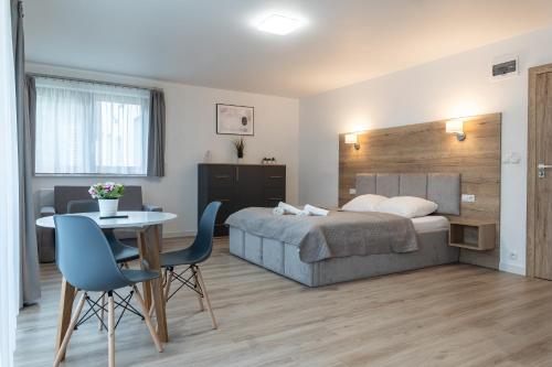 Un dormitorio con una cama y una mesa y sillas. en Apartamenty Aspen, en Karpacz