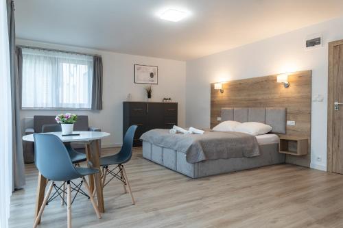 sypialnia z łóżkiem, stołem i krzesłami w obiekcie Apartamenty Aspen w mieście Karpacz