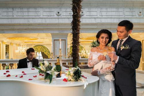 a bride and groom standing in front of a table at Rixos Khadisha Shymkent in Shymkent