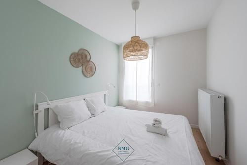 une chambre avec un lit blanc et une fenêtre dans l'établissement Ariane place Disneyland BMYGUEST, à Chessy