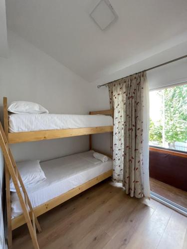 a room with two bunk beds and a window at Ladi Rooms in Tirana