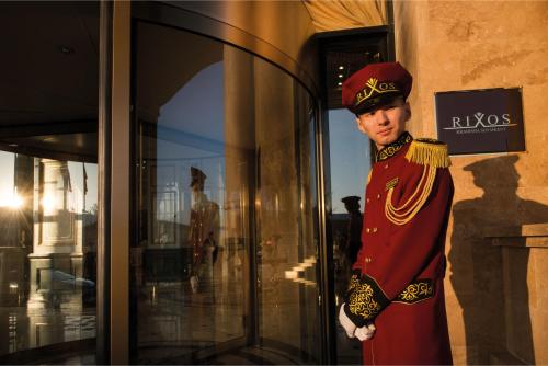 a man in uniform standing in front of a store at Rixos Khadisha Shymkent in Shymkent